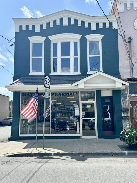 Matthews Pharmacy storefront and sign on Canal Street